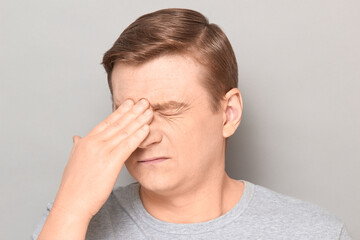Fototapeta premium Portrait of tired man touching bridge of his nose with hand