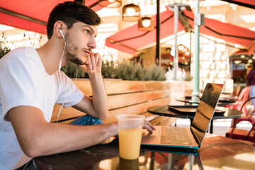 Young man using his laptop in a coffee shop.