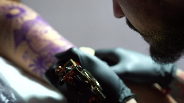Tattooing. creating picture on his back by a professional tattoo artis