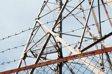 Security with barbed wire fence. 5G telecommunications tower security.