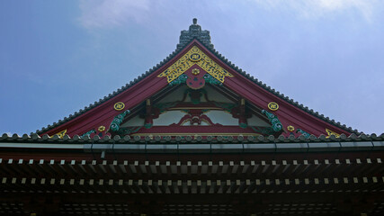 Fototapeta na wymiar Roof of a beautiful ancient buddhist temple in japan predominating de color red