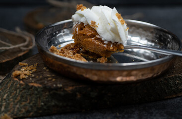 Pumpkin mousse and whipped cream  on serving spoon, close up