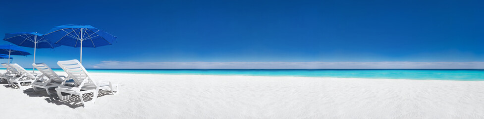 Caribbean beach with blue sun umbrellas and white beds. Tropical vacation