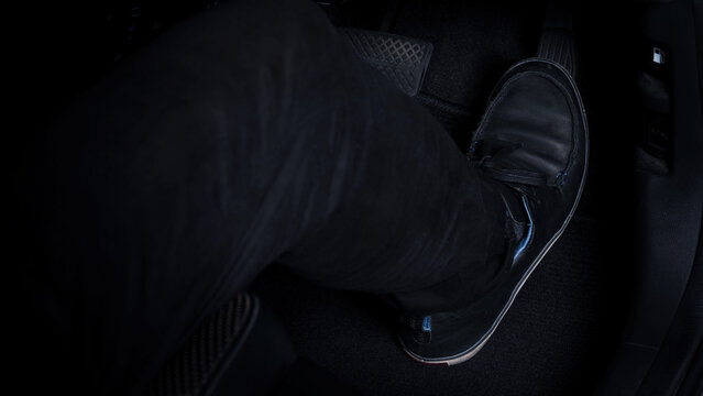 Close up images of man driving car by pushing accelerator and brake pedal with right foot black leather shoe and black jean pant. camera shot inside the japanese car.