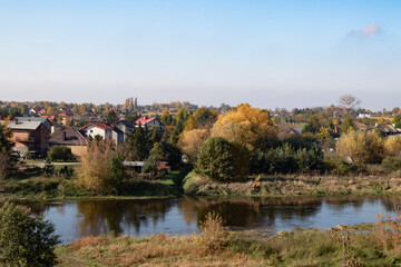 Fototapeta na wymiar autumn landscape with lake, trees and houses