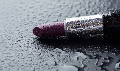 Purple lipstick in drops of water