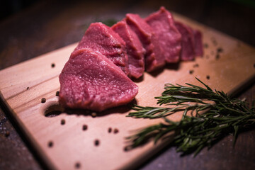 Beef on a cutting board with spices and rosemary