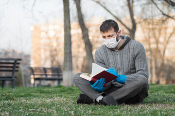 Fototapeta premium reading book outdoors in mask and gloves