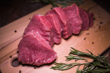 Beef on a cutting board with spices and rosemary
