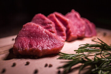 Beef on a cutting board with spices and rosemary