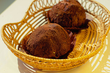 Two delicious handmade chocolates truffle in wickers plate on white background.