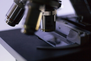 close-up side view of a biological microscope, while analyzing a hair.