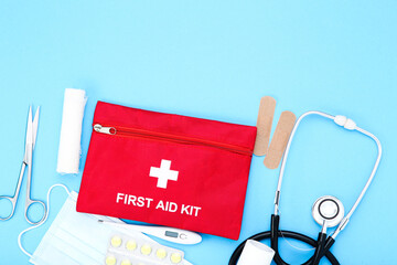 First aid kit with medical supplies on blue background