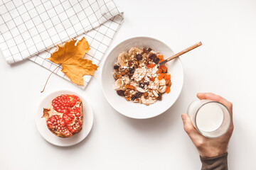Carbohydrate healthy breakfast. Oatmeal with dried fruits on a white plate. View from above
