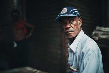 Black man looking away from camera in a dark alley