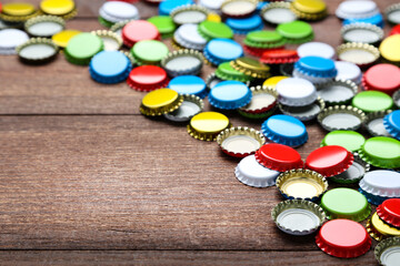 Colorful bottle caps on brown wooden table