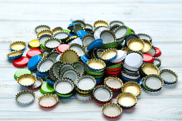 Colorful bottle caps on white wooden table