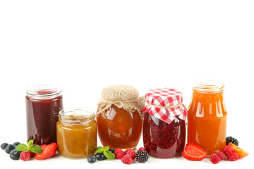 Fototapeta na wymiar Sweet jam in glass jars and ripe berries isolated on white background