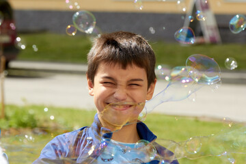 boy blowing bubbles in the summer sun joy