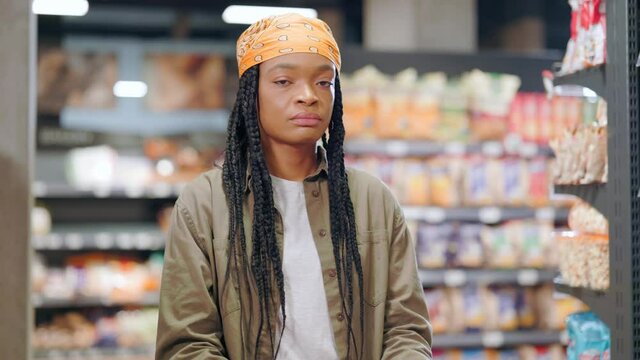 Indoor portrait doubtful african american female customer shrugging shoulders hesitating dont know what to buy. Expressions and gestures. Supermarket. Customer.