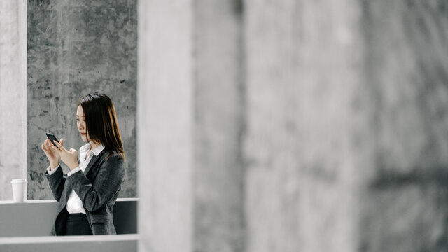 Businesswoman Using Cell Phone In Office Buildings