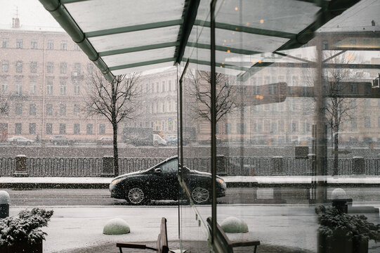 Car on a snowy dday in Saint Petersburg, Russia. Reflection seen in a glass bus stop.