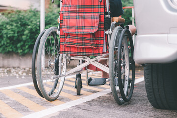 Asian special child on wheelchair beside the car on the parking space for disabled people, Life in the education age and public transport of disabled children, Disability kids transportation concept.