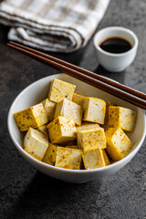 Dices of marinated tofu in bowl.