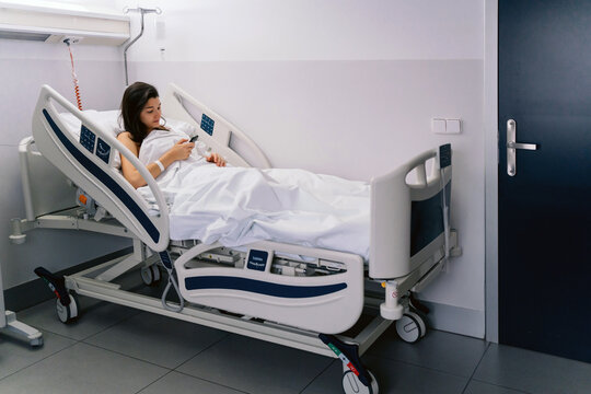 Female Patient In A Hospital Checking Her Phone.