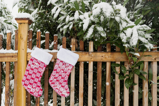 Christmas stockings hung on a snowy fence
