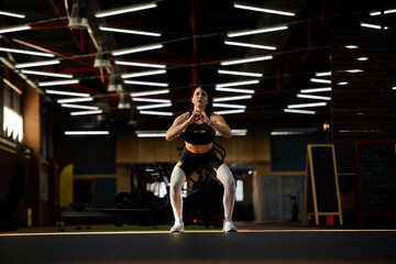 Sporty athlete girl stretching before a workout in a fancy gym