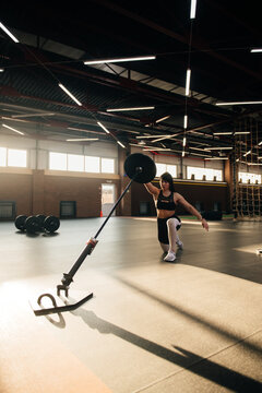 Strong and beautiful brunette crossfit athlete doing workout in a fancy gym