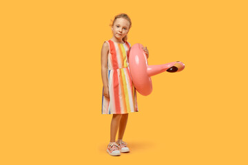 Summer girl in a dress with a swimming circle. Orange isolated background.