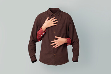 Two caucasian hands hug and empty brown shirt