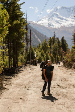 young man travelling in Himalayas with a large backpack