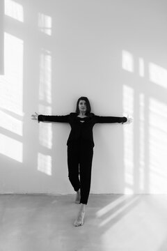 dancing barefooted girl with a back leaned to the wall