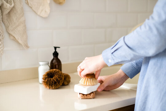 Detail of a woman hands who rubs an eco sponge on an eco and zero waste detergent