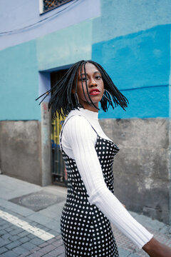 Black Woman Moving Her Hair While Walking And Looking At Camera.