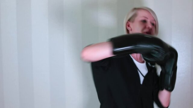 Raising tone of the muscles of the arms and body. Burning fat in self-isolation. Portrait of a woman doing a workout at home with boxing gloves. 