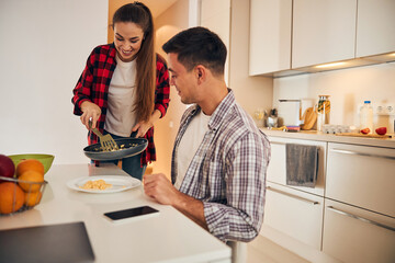 Housewife serving breakfast to her male spouse