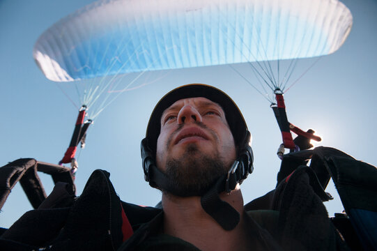 A selfie of young man paragliding on a sunny day in the mountains