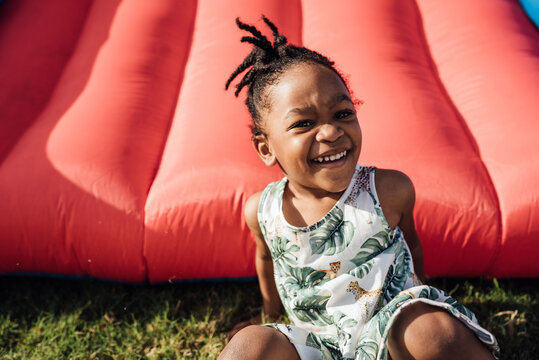 Little Girl in dress smiling in the jump house