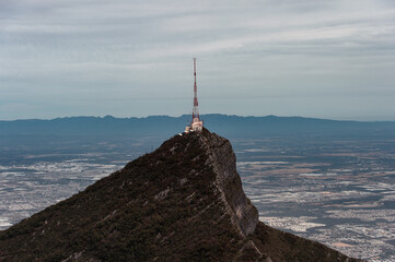 Relay tower on the top of a mountain high above the city line