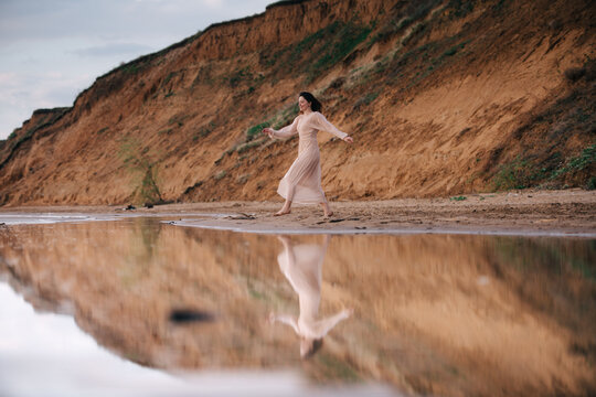 Beautiful woman in an exquisite running toward the river