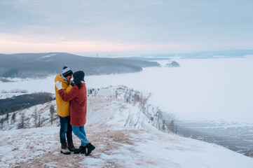 Winter love story. Young couple having fun in the mountains