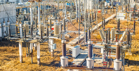 industrial background of high voltage substation on yellow dry grass backdrop Power circuit breaker...
