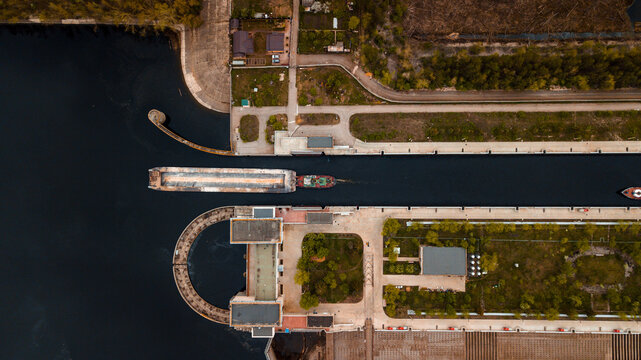 Top-view of a barge ship passing by the gateway