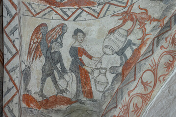 An ancient fresco shows a woman and two devils pouring beer from a barrel