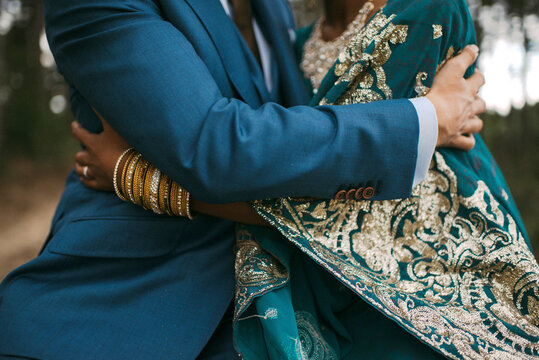Indian bride and groom with blue costume holding and cuddling each other