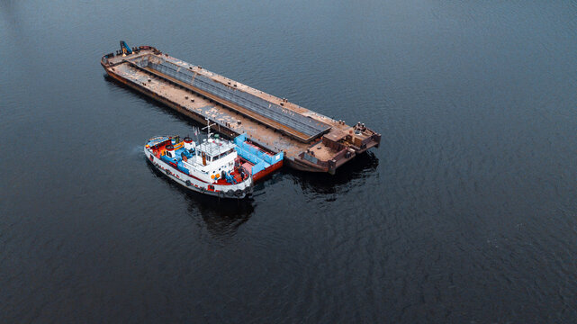 Top-view of a small ship near the empty barge